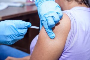 Close-up shot of a healthcare professional giving a vaccine injection.